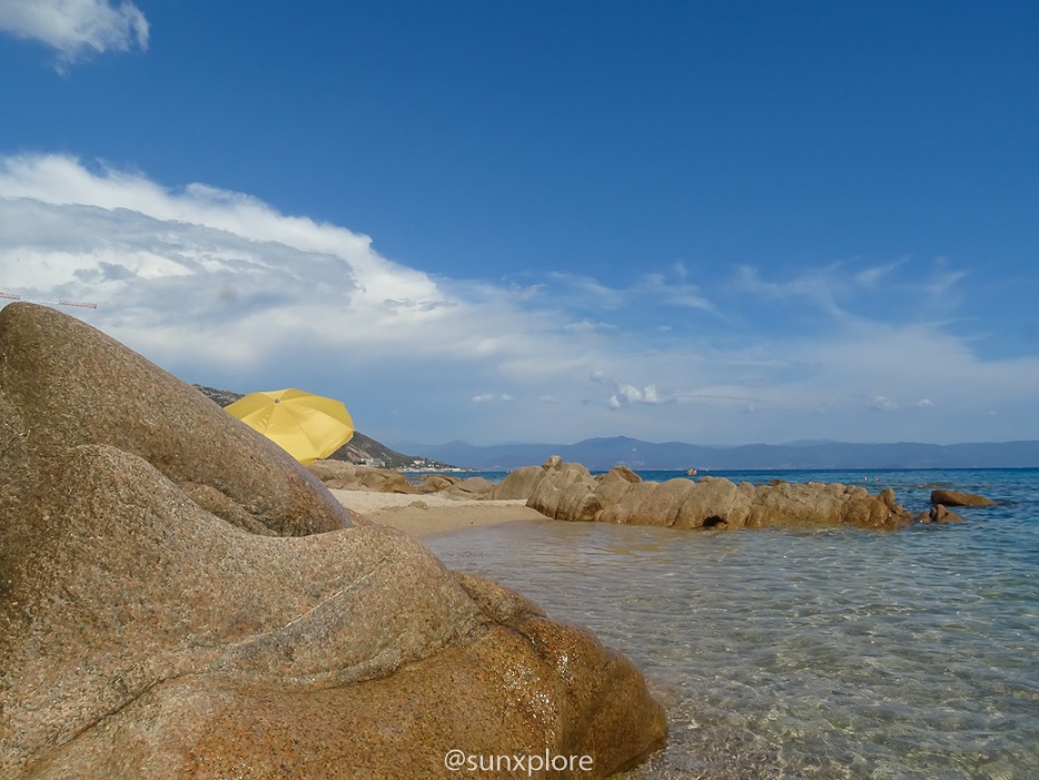 Un parasol entre les rochers sur une des plus belles plages de Corse, à Ajaccio : la plage moorea