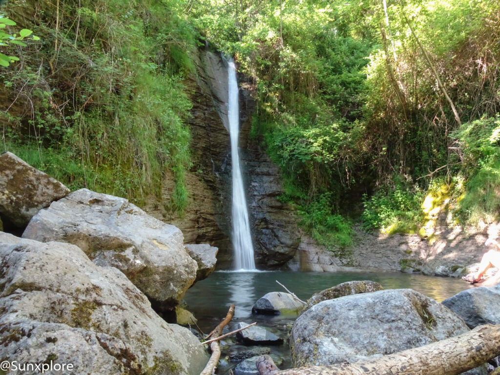 Grande cascade tombant d'une falaise au cœur de la forêt.