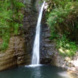 Haute cascade tombant le long d'une falaise rocheuse au cœur de la forêt près de Montélimar.