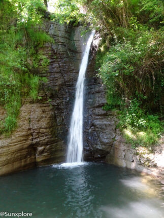 Haute cascade tombant le long d'une falaise rocheuse au cœur de la forêt près de Montélimar.