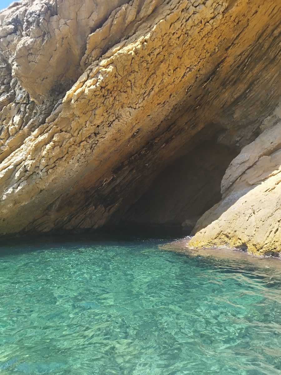 Falaises ocres de la calanque de la Madrague plongeant dans une eau turquoise