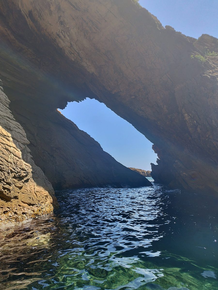 Passage sous l'arche rocheuse de la calanque de la Madrague en kayak